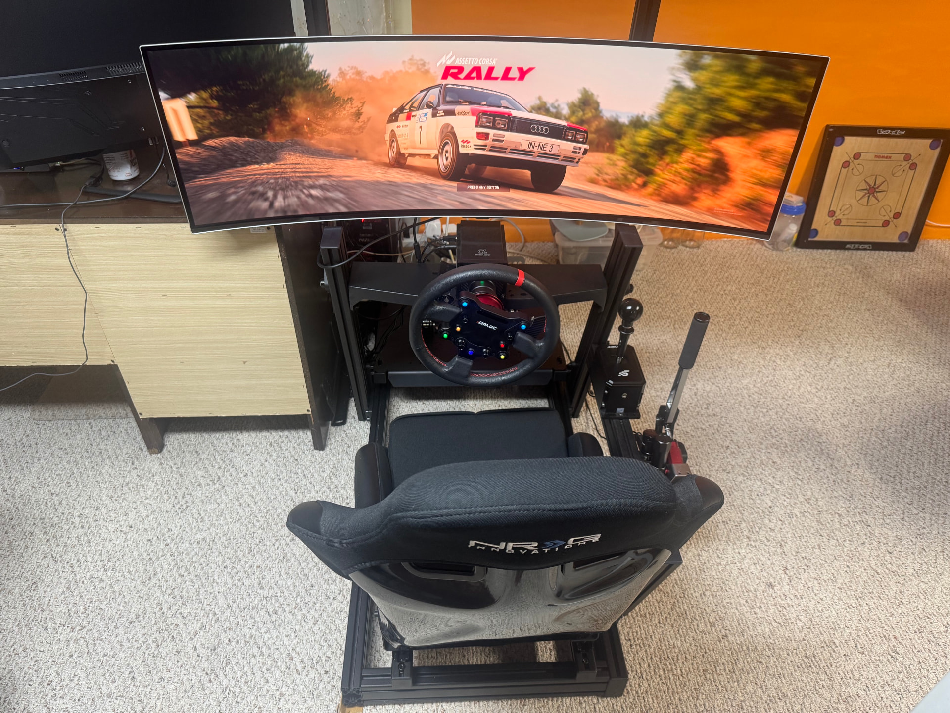 Custom racing simulator with ultrawide monitor, wheel, shifter, handbrake, and racing seat
